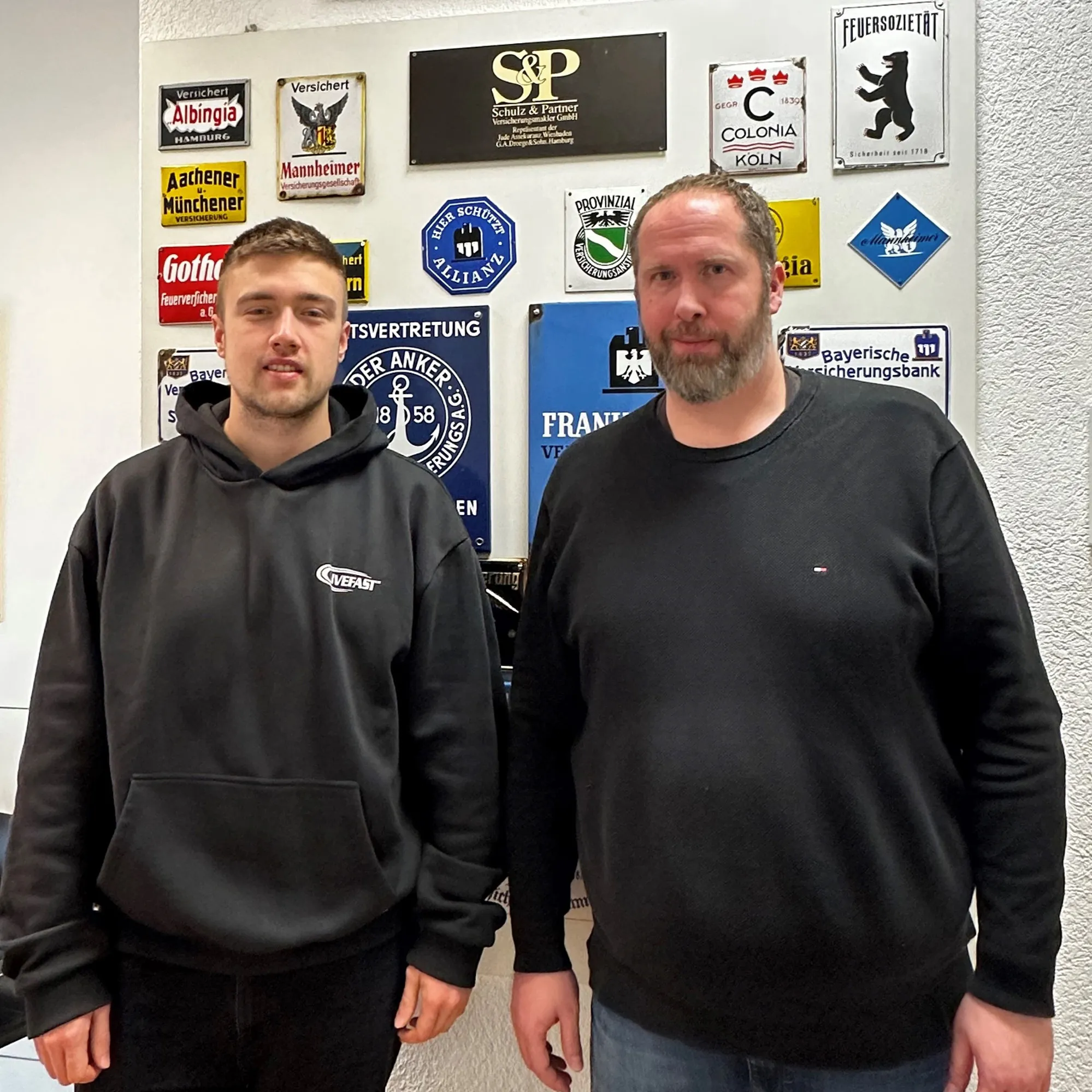 Zwei Personen vor einer Sponsorenwand